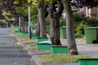 green recycling boxes along a tree lined street