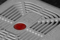 Picture of a white smoke alarm with red button