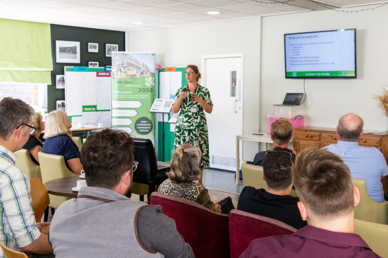 A woman speaks to a group about the business grant fund