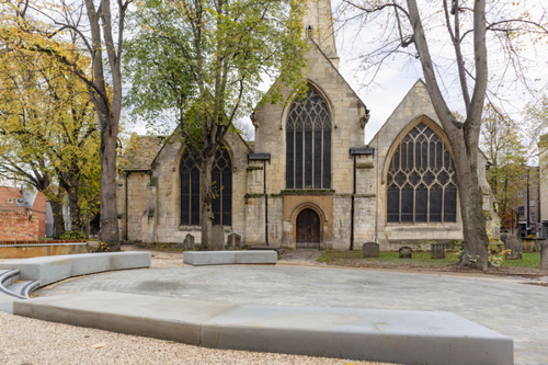 View of Cheltenham Minster showing new paving and seating installed as part of the Minster Gardens project