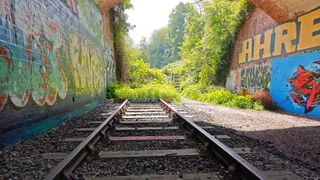 Old train tracks under the bridge at Pilley Bridge Nature Reserve - colourful graffiti on the brick walls
