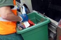 A recycling operative emptying a green recycling box