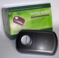 Rectangular black plastic device next to green box. Box and device display the words "energy-saving box"