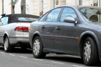 grey hatchback and silver soft-top cars parked in on-street parking bays