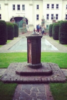 brick plinth in front of italian style garden with pool and formal hedges