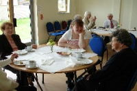 Three people sat around a table at a community event