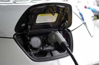 Electric vehicle plugged into charging point