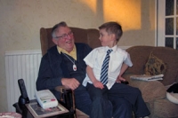Elderly man wearing lifeline alarm with child on his lap