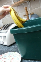 Putting a banana skin into food caddy