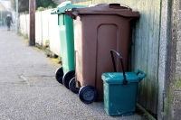 waste and recycling bins put out on a street