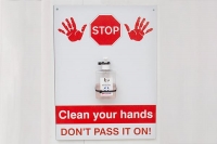 Sign with sanitiser attached reminding people to clean their hands