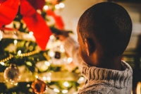 Child decorating a Christmas tree