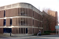 a brown and grey concrete building housing a multi-storey car park