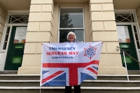 Deputy Mayor Sandra Holliday, holding the Emergency Services Day flag