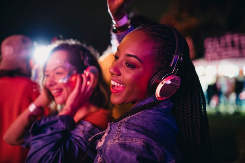 Two women dancing with headphones on at a silent disco