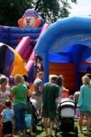 Adults and children in front of a brightly coloured bouncy castle